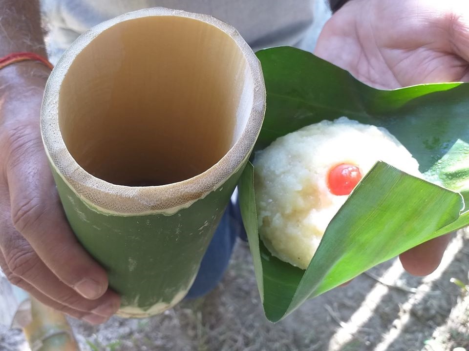 Food served on Banana leaf and drinks in a bamboo cup